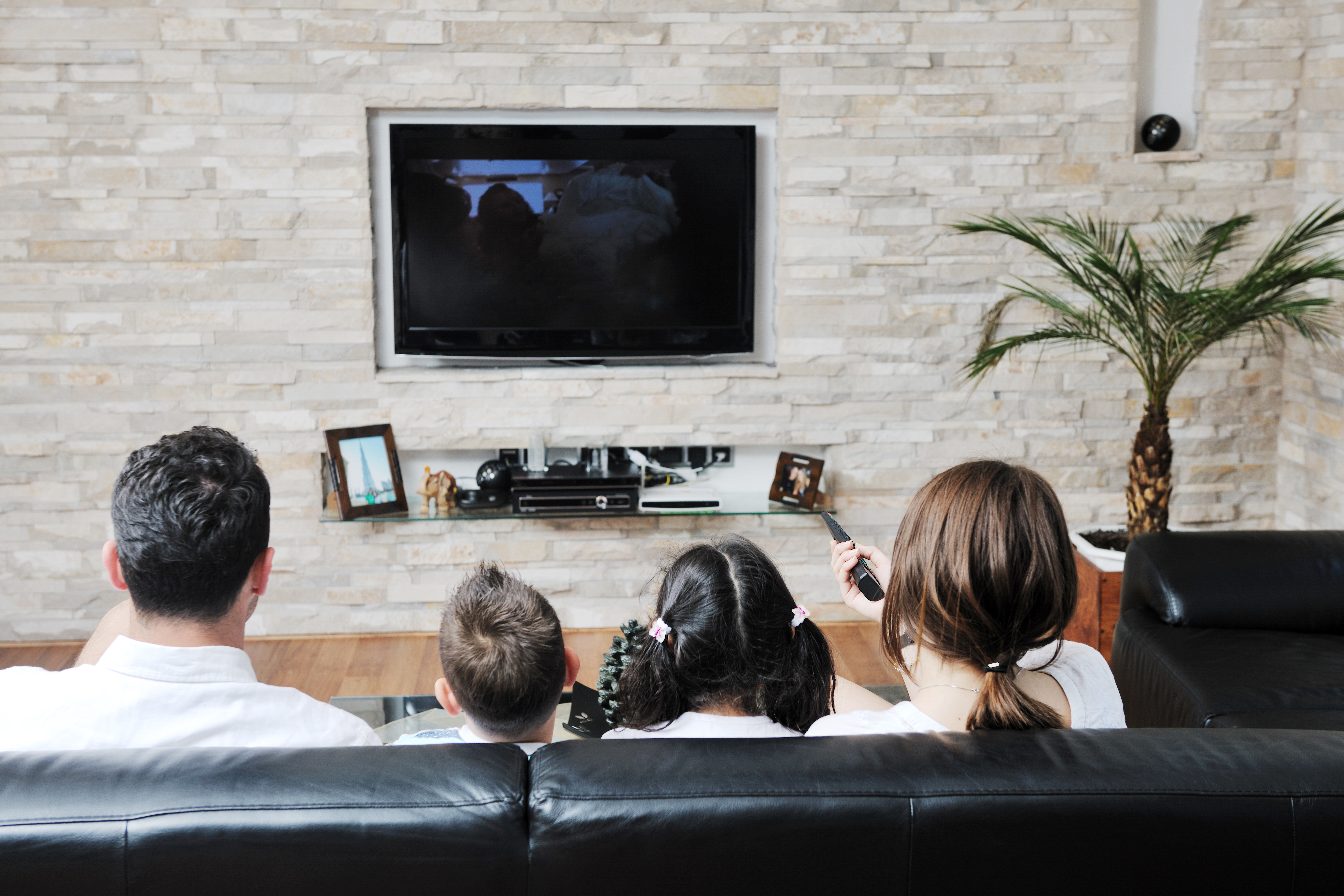 Image of living room with an affordable tv being used by a family